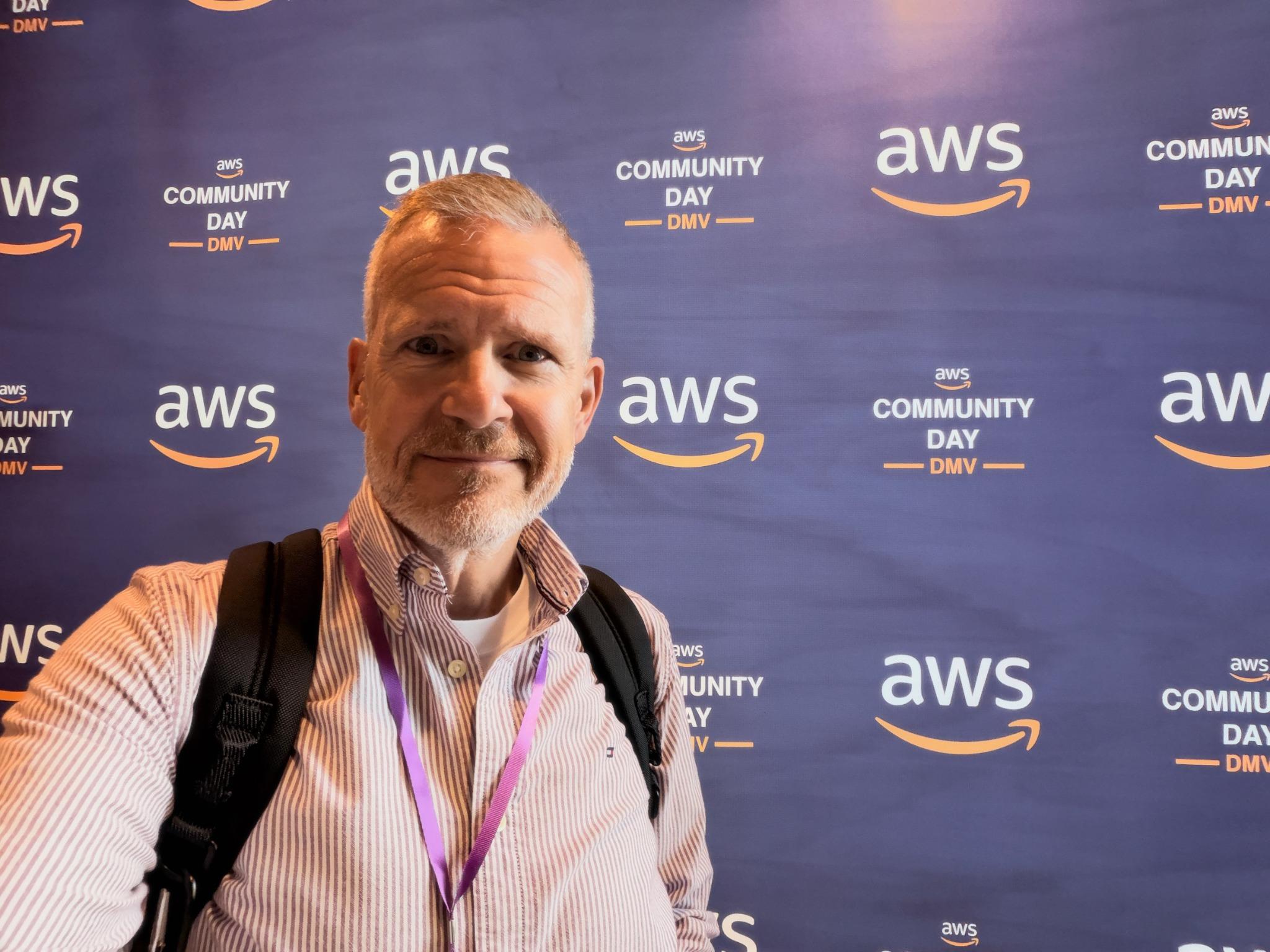 Joe Hummel in front of the AWS Community Day DMV backdrop.